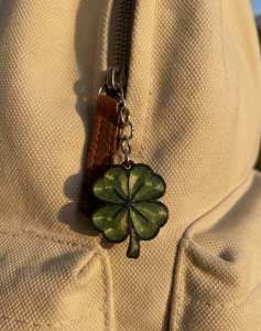 Porte-clés trèfle 3D vert accroché à une anse de sac en toile
