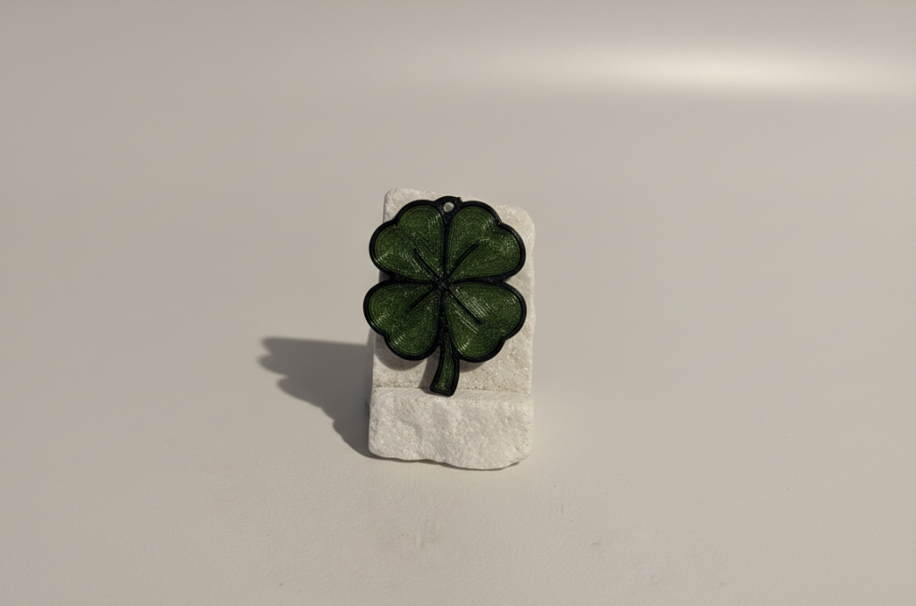 Porte-clés trèfle à quatre feuilles imprimé en 3D posé sur un socle