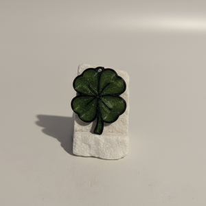 Porte-clés trèfle à quatre feuilles imprimé en 3D posé sur un socle
